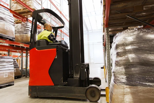 Man på gaffeltruck laddar last på lager — Stockfoto