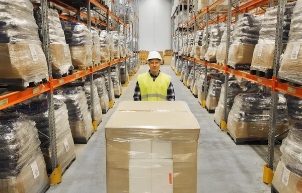 Uomo sorridente in hardhat carico al magazzino — Foto Stock