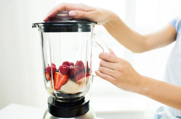 Close up of woman with blender making fruit shake — Stock Photo, Image