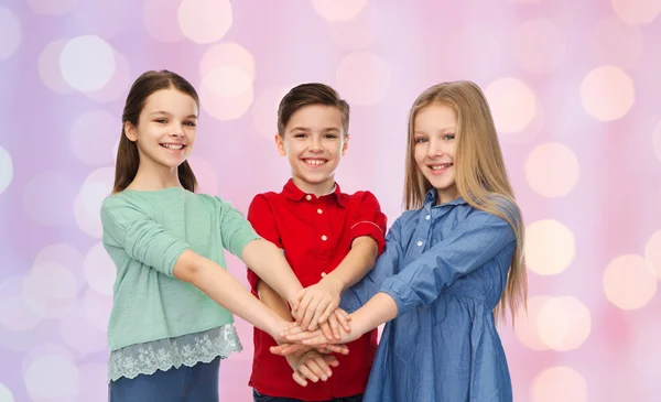 De gelukkige kinderen met handen bovenop — Stockfoto