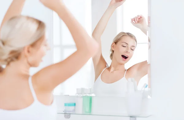 Femme bâillant devant le miroir à la salle de bain — Photo