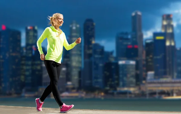 Femme heureuse jogging sur fond de rue de la ville — Photo