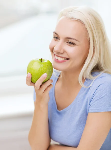 Ευτυχισμένη γυναίκα τρώει πράσινο μήλο στο σπίτι — Φωτογραφία Αρχείου