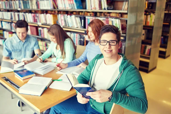 Estudantes com livros que se preparam para exame na biblioteca — Fotografia de Stock