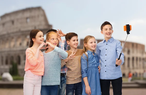 Kids with smartphone selfie stick over coliseum — Zdjęcie stockowe