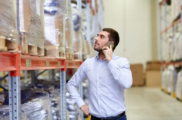 Hombre serio llamando en el teléfono inteligente en el almacén — Foto de Stock