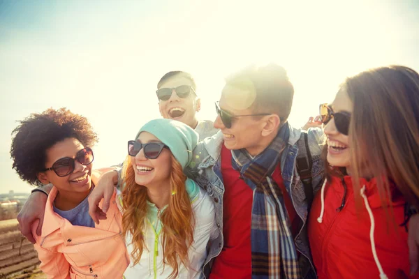 Amici sorridenti in occhiali da sole ridendo sulla strada — Foto Stock