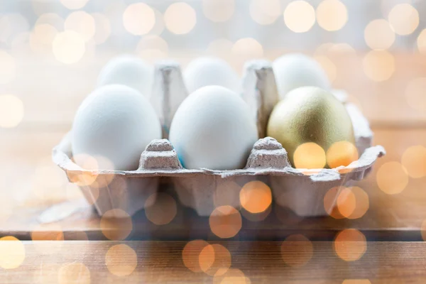 Nahaufnahme von weißen und goldenen Eiern in Eierschachtel — Stockfoto