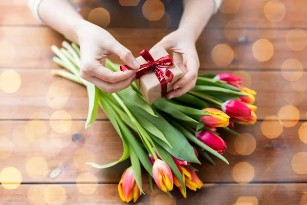 Primer plano de la mujer con caja de regalo y flores de tulipán — Foto de Stock