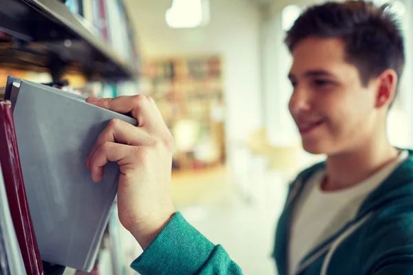 Close up de menino estudante feliz com livro na biblioteca — Fotografia de Stock