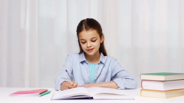 Heureuse écolière avec des livres et bloc-notes à la maison — Video