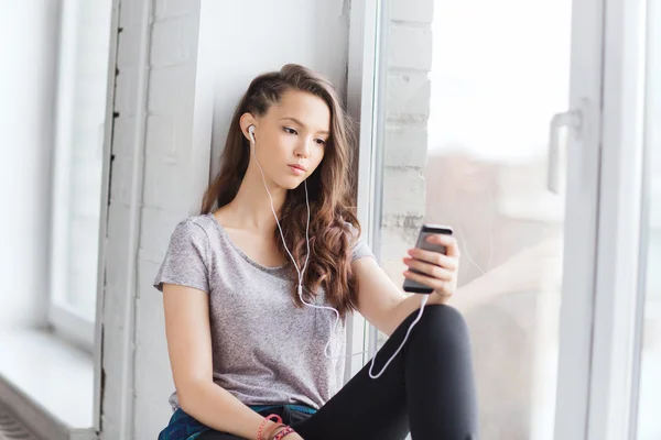 Menina adolescente com smartphone e fones de ouvido — Fotografia de Stock