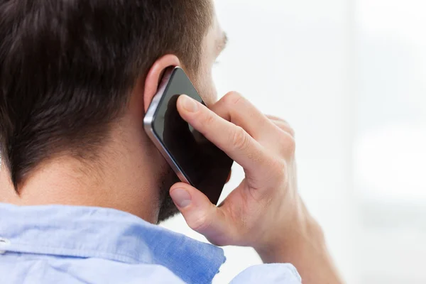 Close up of man calling on smartphone at home — Stock Photo, Image