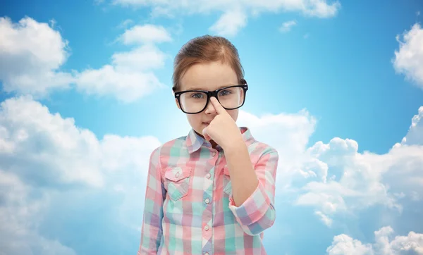 Happy little girl in eyeglasses over blue sky — Stock Photo, Image