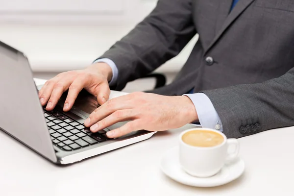 Närbild på affärsman med kaffe och laptop — Stockfoto