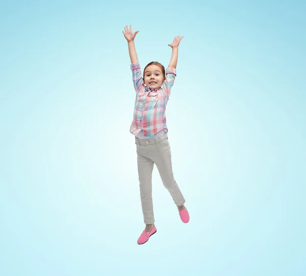Gelukkig klein meisje in de lucht springen over blauw — Stockfoto