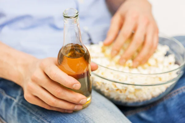 Primer plano del hombre con palomitas de maíz y cerveza en casa — Foto de Stock