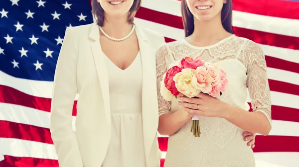 Close up de feliz casal lésbico com flores — Fotografia de Stock