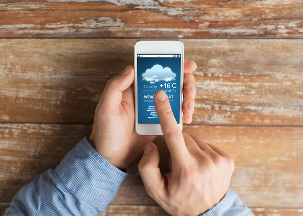 Close up of male hands with smartphone on table — Stock Photo, Image