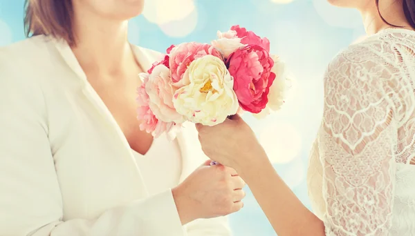 Close up de feliz casal lésbico com flores — Fotografia de Stock