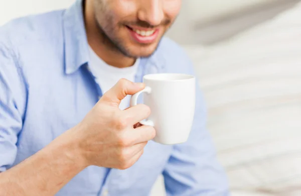 Close up de homem com chá ou xícara de café em casa — Fotografia de Stock