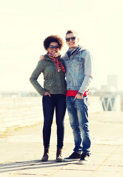 Happy teenage friends in shades hugging outdoors — Stock Photo, Image