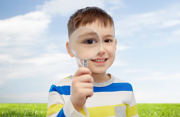 Glücklicher kleiner Junge, der durch die Lupe schaut — Stockfoto