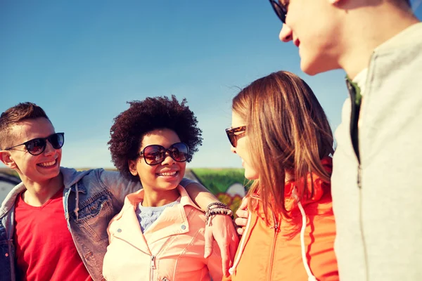 Happy teenage friends in shades talking on street — Stock Photo, Image