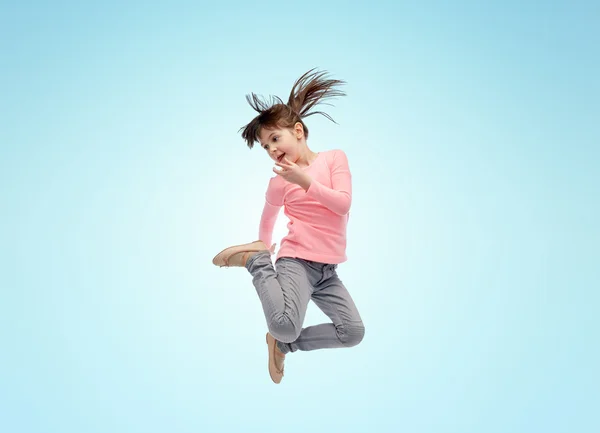 Glückliches kleines Mädchen springt in der Luft über blau — Stockfoto