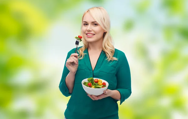Χαμογελώντας νεαρή γυναίκα τρώει σαλάτα λαχανικών — Φωτογραφία Αρχείου