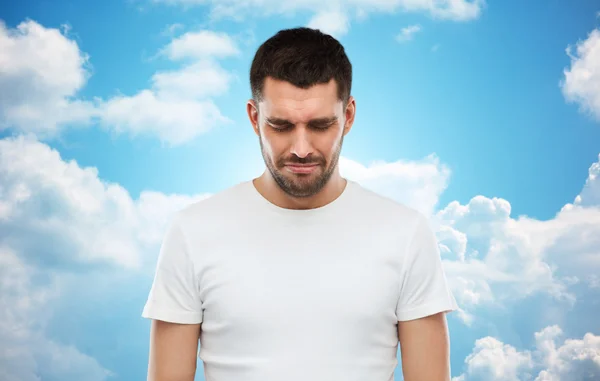 Unhappy young man over blue sky background — Stok fotoğraf