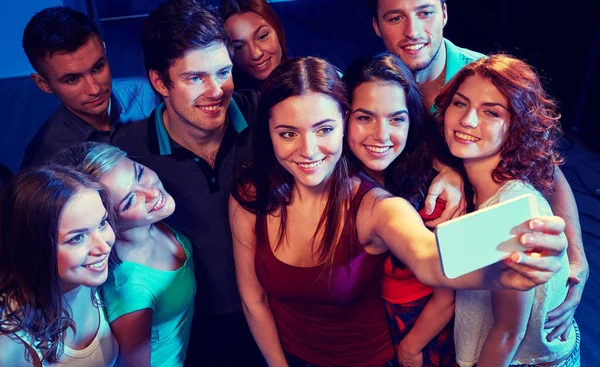 Amis avec smartphone prendre selfie en club — Photo