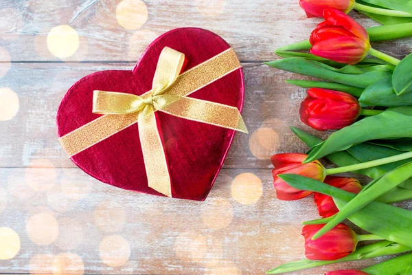 Close up de tulipas vermelhas e caixa de chocolate — Fotografia de Stock
