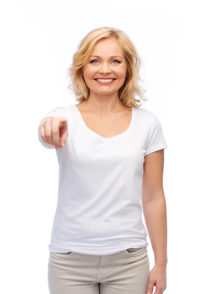 Smiling woman in white t-shirt pointing to you — Stock Photo, Image