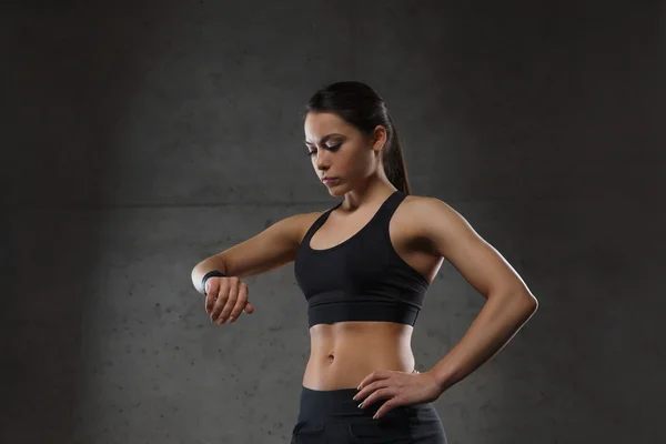 Jeune femme avec montre de fréquence cardiaque dans la salle de gym — Photo