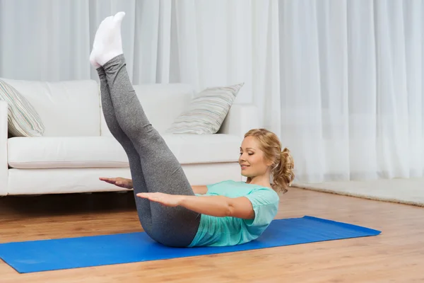 Woman exercising on mat at home — Stock Photo, Image