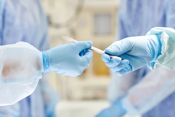 Close up of hands with scalpel at operation — Stock Photo, Image