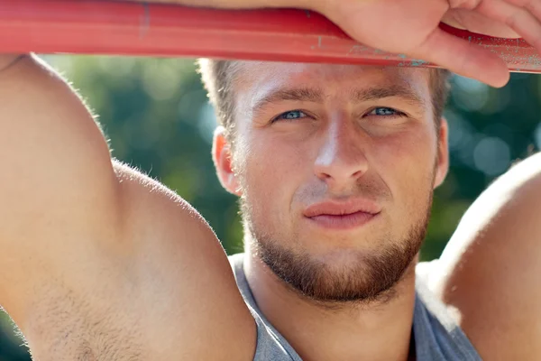 Junger Mann turnt im Freien am Reck — Stockfoto