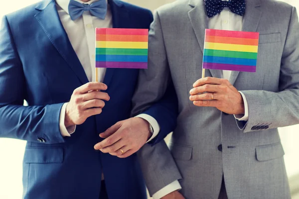 Close up de masculino gay casal segurando arco-íris bandeiras — Fotografia de Stock