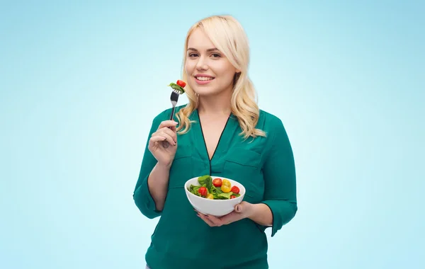 Lachende jonge vrouw eten plantaardige salade — Stockfoto