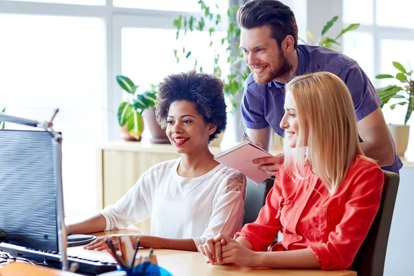 Equipe criativa feliz com computador no escritório — Fotografia de Stock