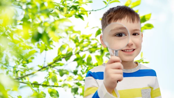 Happy little boy looking through magnifying glass — Stock Photo, Image