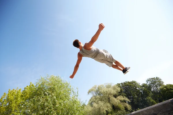 Sportig ung man hoppa i sommaren park — Stockfoto