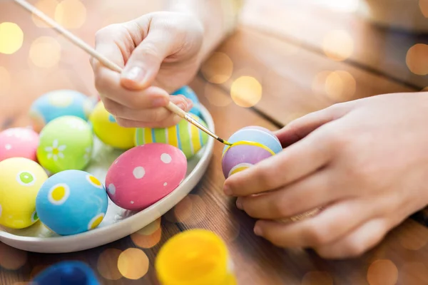 Close up of woman hands coloring easter eggs — Stock Photo, Image