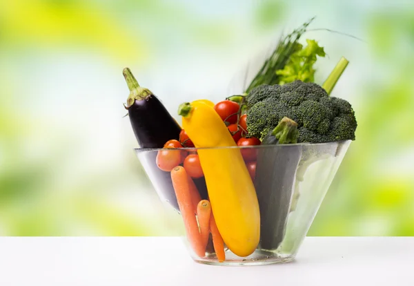 Närbild på mogen grönsaker i glasskål på bord — Stockfoto