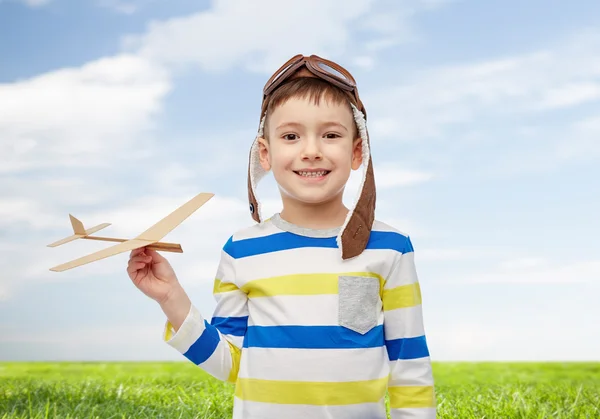 Glücklicher kleiner Junge mit Fliegermütze und Flugzeug — Stockfoto