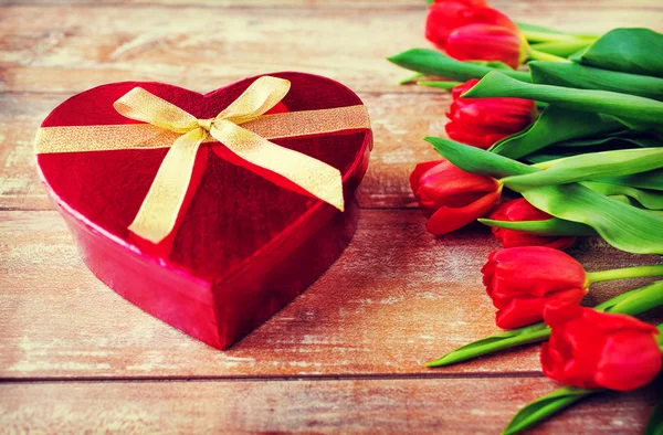 Czerwone tulipany i czekoladowe pudełko z bliska — Zdjęcie stockowe
