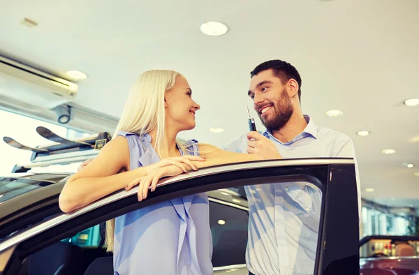 Happy couple buying car in auto show or salon — Stock Photo, Image