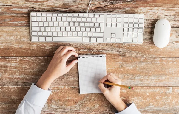 Close up of hands with notebook and keyboard — Stock Photo, Image