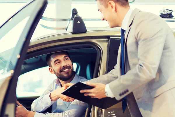 Happy man with car dealer in auto show or salon — Stock Photo, Image